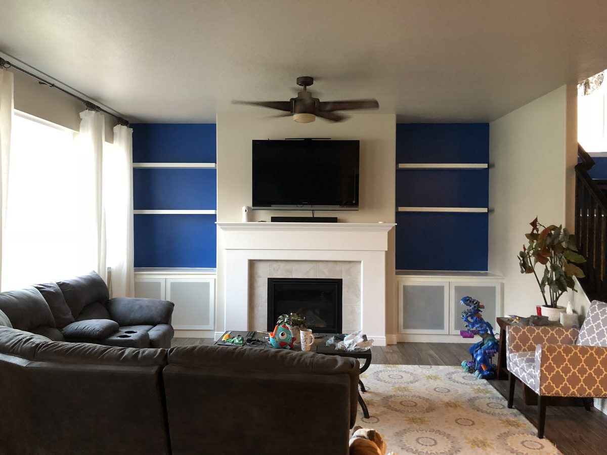 Built-in shelving flanking fireplace with TV mount, full room view